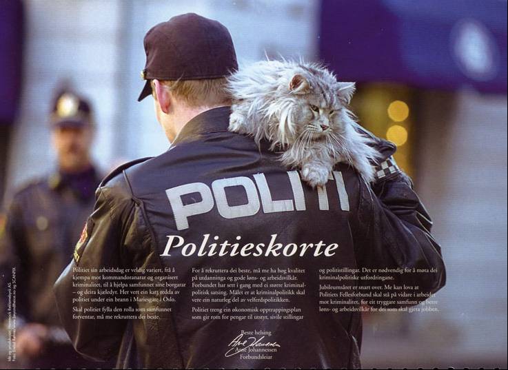 En politimann med en katt på skuldra