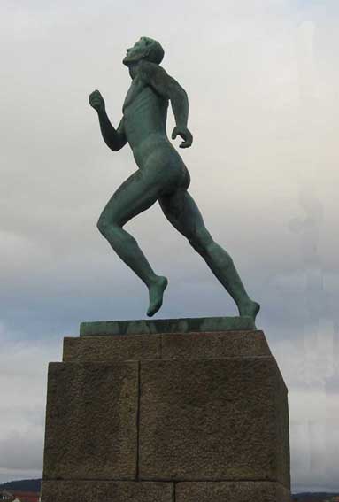 skulptur i patinert bronse som fungerer som både krigs- og idrettsmonument. Den viser en naken løpende mann i det øyeblikket han er i mål. Figuren står på en flere meter høy sokkel