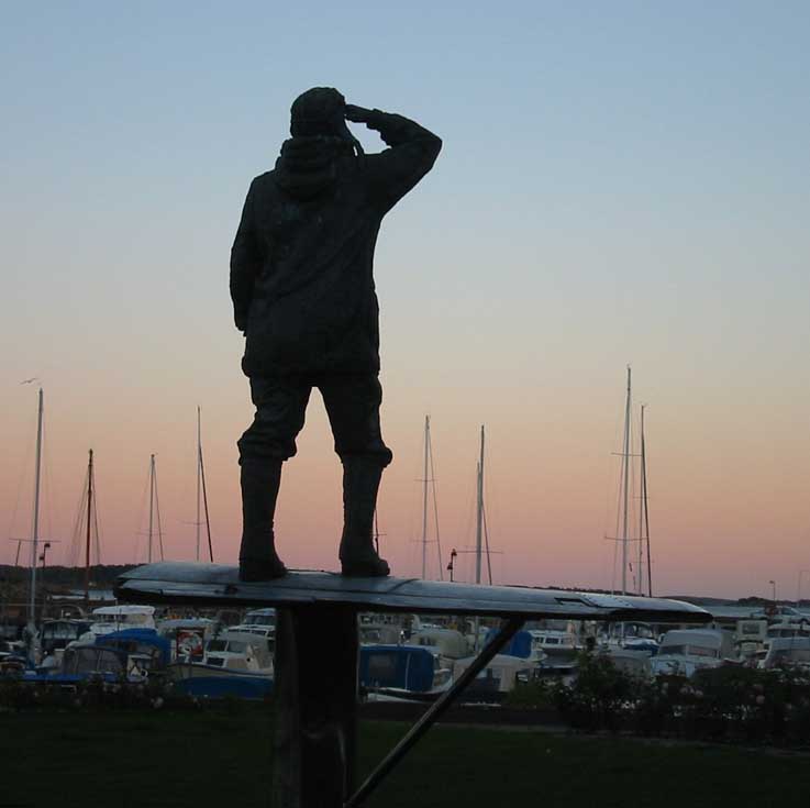 bronsestatue av flygerhelten Bernt Balchen fra baksiden i solnedgang
