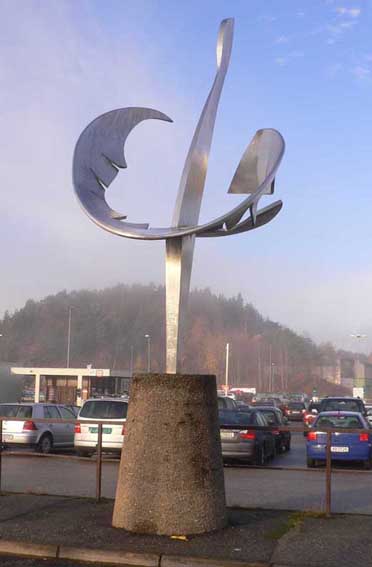 skulptur i stål på en meget høy søyle, er satt opp ved parkeringsplassen på Kristiansand lufthavn Kjevik
