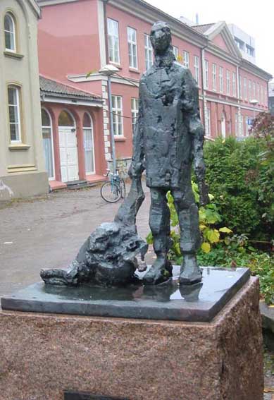 skulptur i bronse av mann med slakterkniv og et avkuttet kjøttstykke