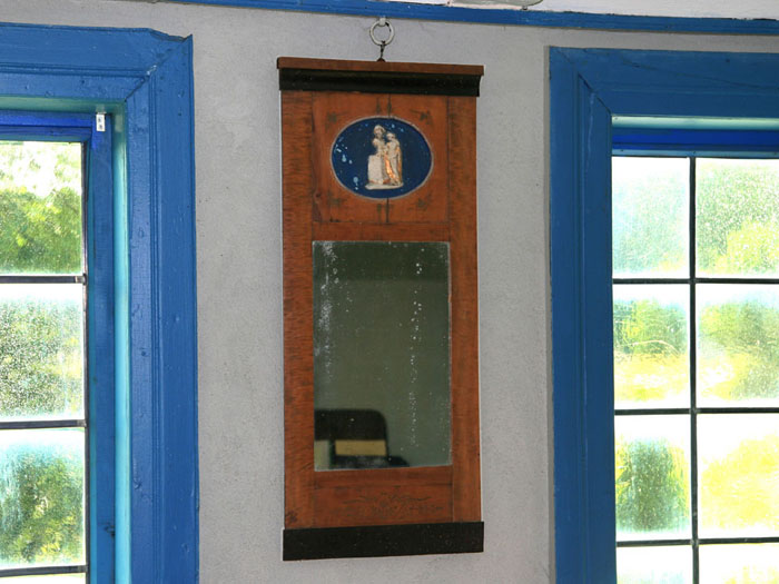 speil på veggen mellom vinduene