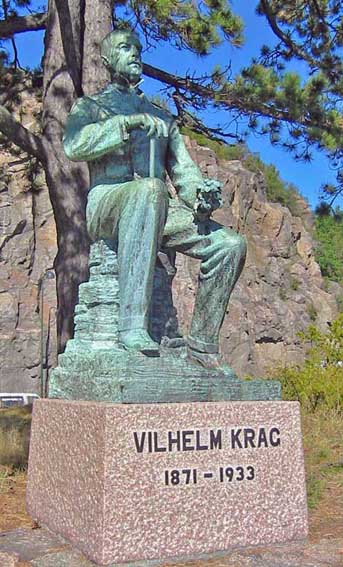 Helfigur i bronse av Vilhelm Krag sittende, skuer utover fjorden